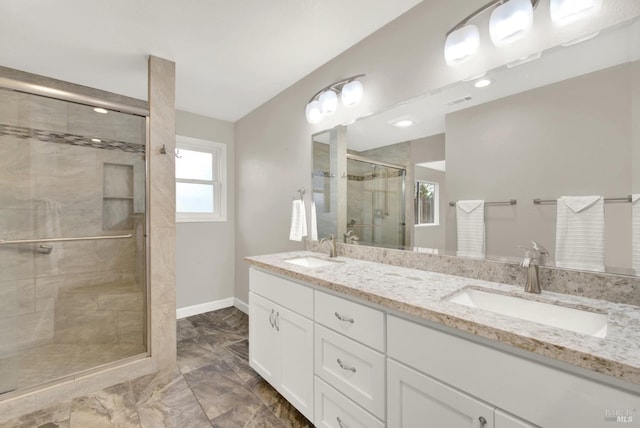 full bathroom with a sink, baseboards, a stall shower, and double vanity