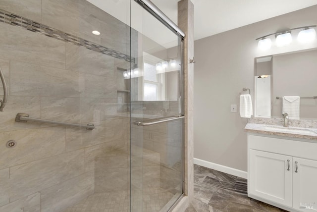 full bath featuring baseboards, a stall shower, and vanity