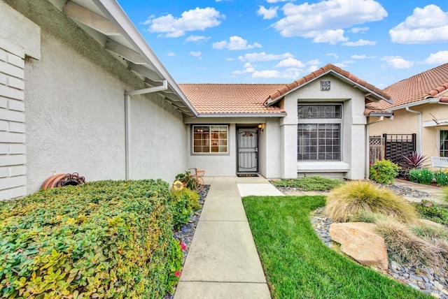 property entrance featuring stucco siding and a tiled roof