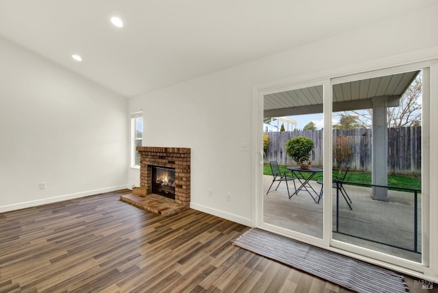 unfurnished living room featuring recessed lighting, a fireplace, baseboards, and wood finished floors