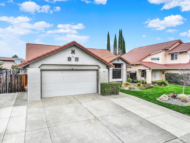 mediterranean / spanish-style home with brick siding, driveway, a garage, and fence