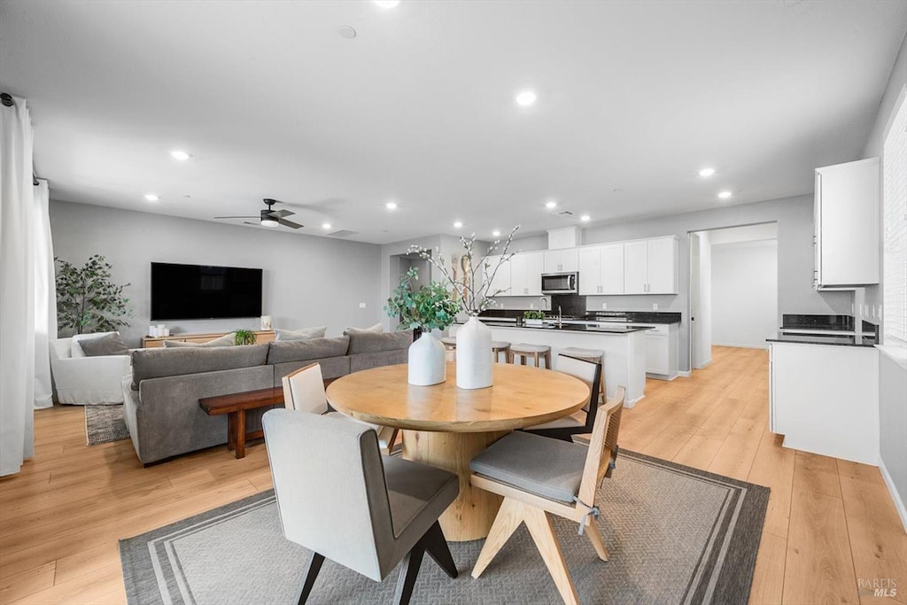 dining area featuring light wood finished floors, a ceiling fan, and recessed lighting