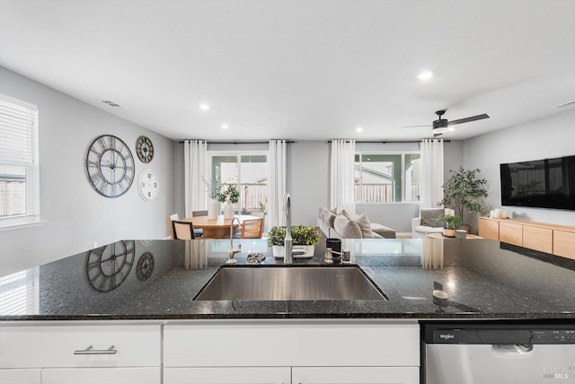 kitchen featuring visible vents, a sink, stainless steel dishwasher, open floor plan, and white cabinetry