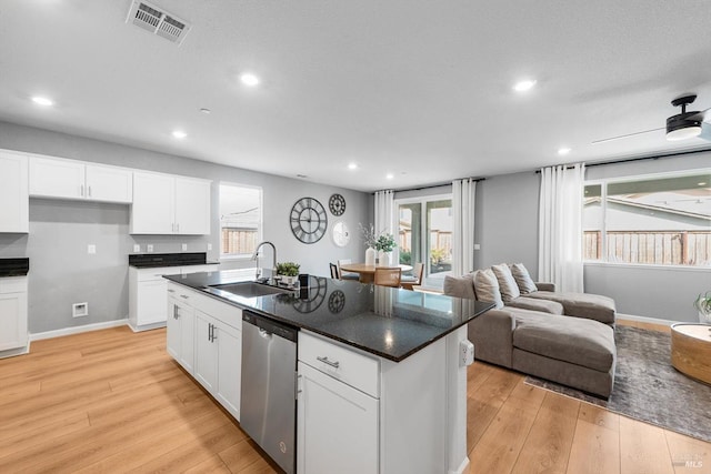 kitchen with visible vents, open floor plan, dishwasher, light wood-style flooring, and a sink