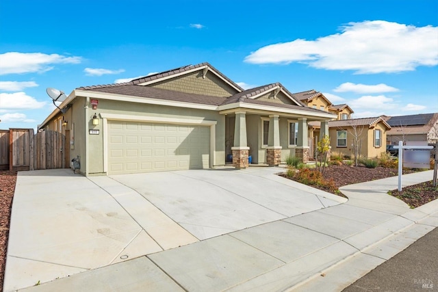 view of front of property featuring fence, a garage, driveway, and stucco siding