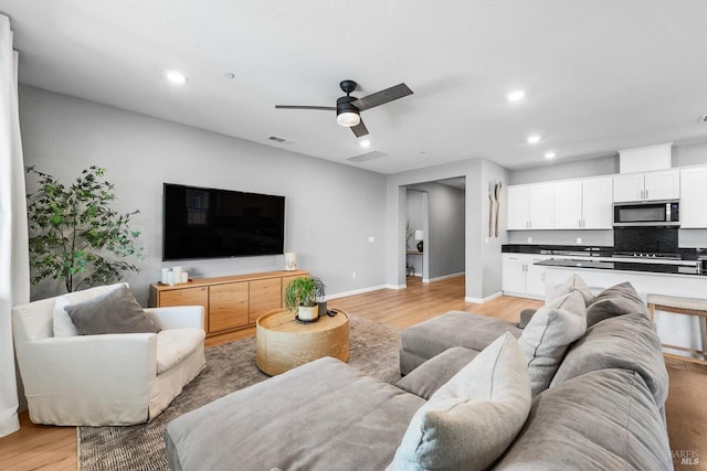 living room featuring visible vents, baseboards, recessed lighting, light wood-style flooring, and a ceiling fan