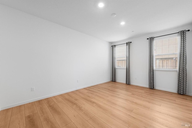 spare room with recessed lighting, light wood-type flooring, and baseboards