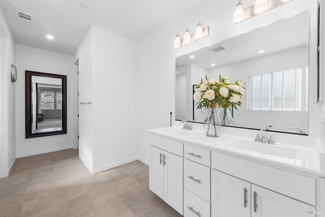 bathroom featuring baseboards, visible vents, and a sink