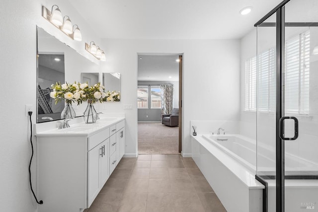 bathroom featuring a sink, a bath, double vanity, and tile patterned floors