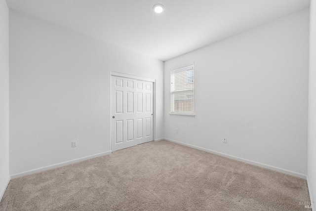 carpeted empty room with baseboards