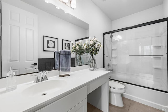 full bathroom featuring tile patterned flooring, toilet, vanity, and shower / bath combination with glass door