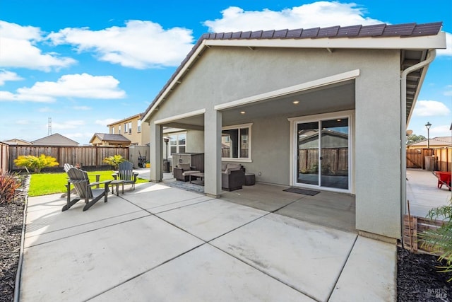 back of house with a fenced backyard, stucco siding, outdoor lounge area, a patio area, and a lawn