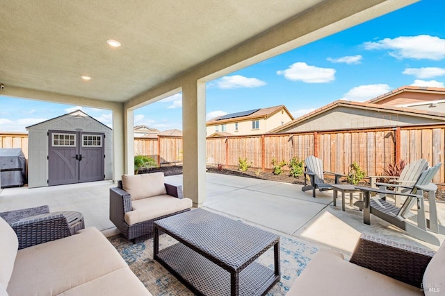 view of patio featuring area for grilling, a fenced backyard, an outdoor structure, a storage unit, and outdoor lounge area