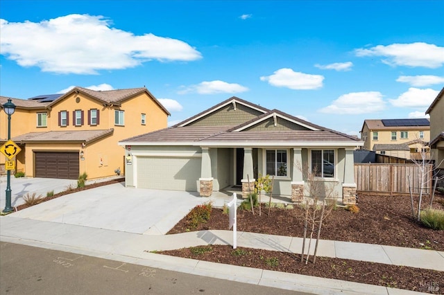 craftsman inspired home with an attached garage, fence, stucco siding, stone siding, and driveway