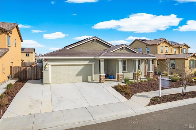 view of front of home with stucco siding, a tile roof, fence, concrete driveway, and an attached garage