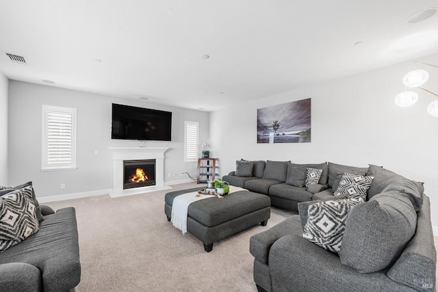 living area featuring a warm lit fireplace, visible vents, light carpet, and baseboards