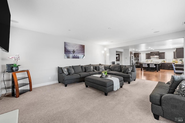 living room with light carpet and baseboards