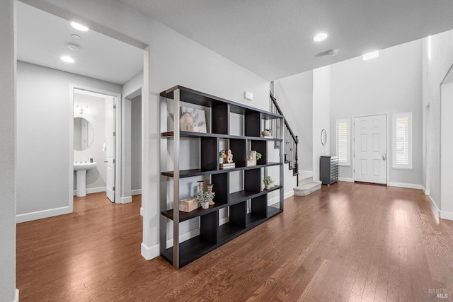 foyer entrance featuring stairway, wood finished floors, and baseboards