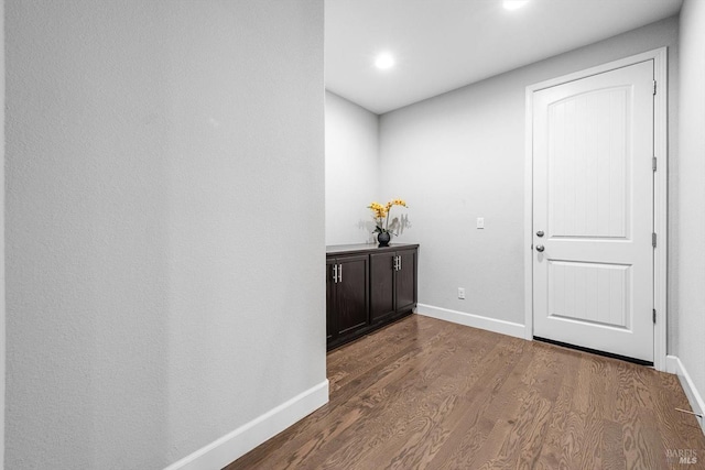 corridor featuring recessed lighting, baseboards, and wood finished floors