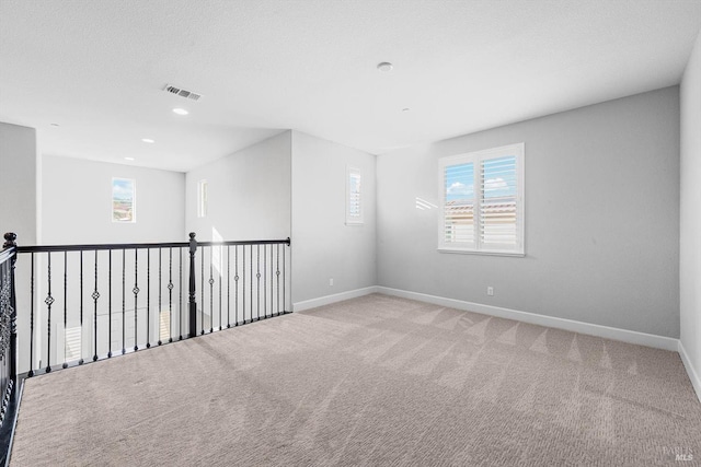 unfurnished room featuring light carpet, recessed lighting, visible vents, and baseboards