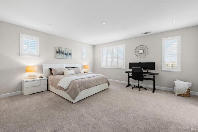 bedroom with light carpet, visible vents, and baseboards