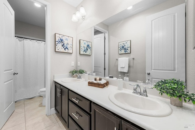 full bath featuring double vanity, tile patterned flooring, a sink, and toilet