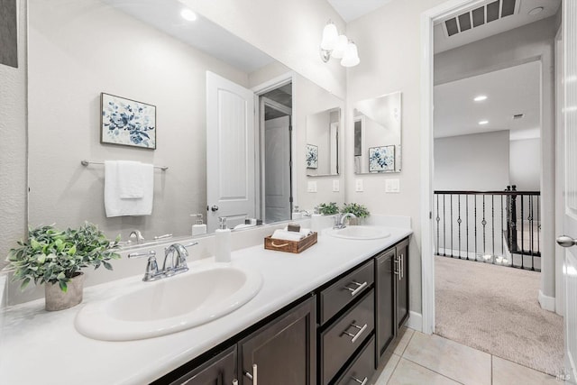 bathroom featuring double vanity, visible vents, a sink, and tile patterned floors