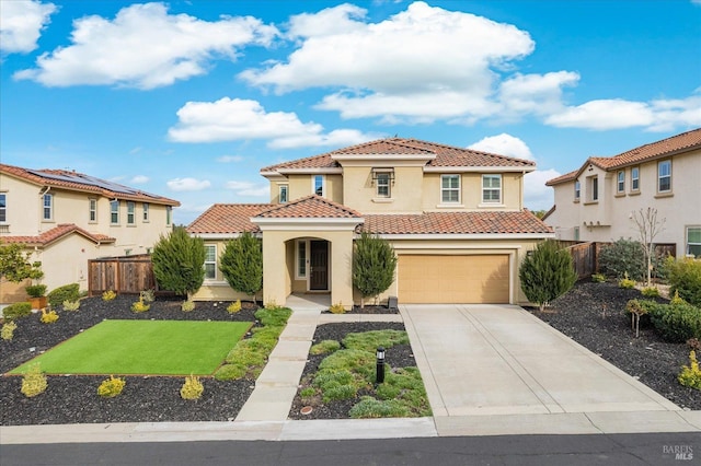 mediterranean / spanish-style home with a tile roof, fence, driveway, and stucco siding