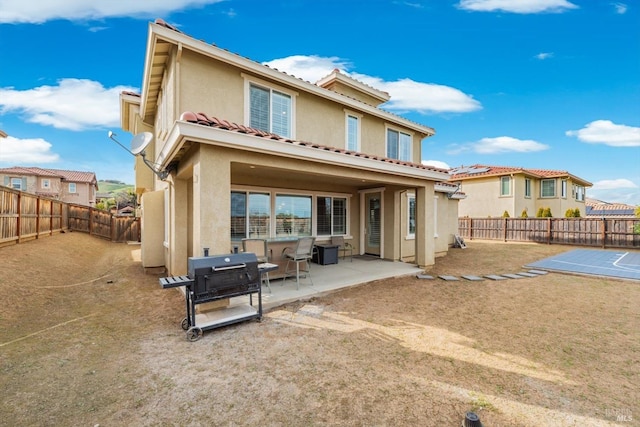 rear view of house with a fenced backyard, a patio, and stucco siding