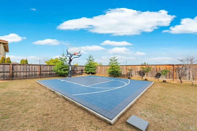 view of basketball court with basketball court, a fenced backyard, and a yard