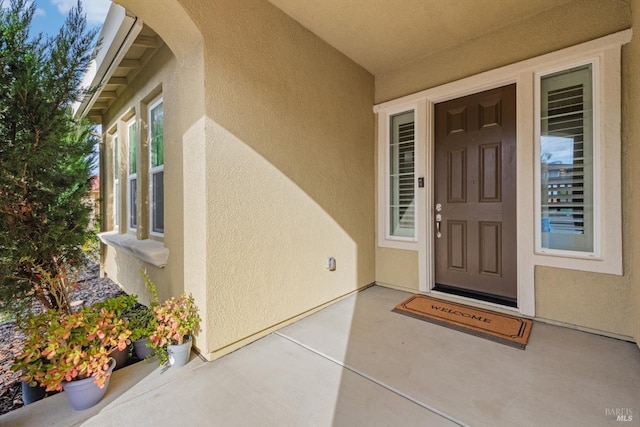 doorway to property featuring stucco siding