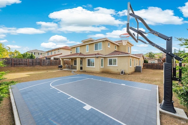 view of basketball court with a yard, a fenced backyard, and basketball court