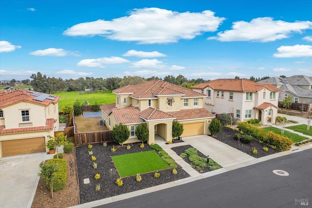 mediterranean / spanish-style house with driveway, an attached garage, a tile roof, and fence