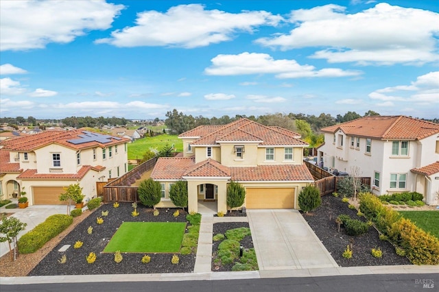 mediterranean / spanish-style home with stucco siding, an attached garage, fence, driveway, and a tiled roof