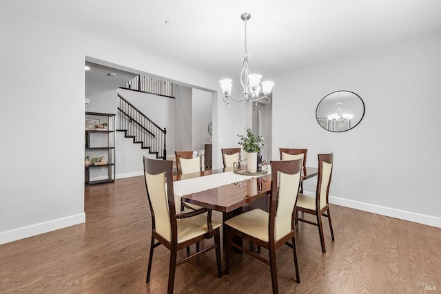 dining space featuring baseboards, stairway, a notable chandelier, and wood finished floors