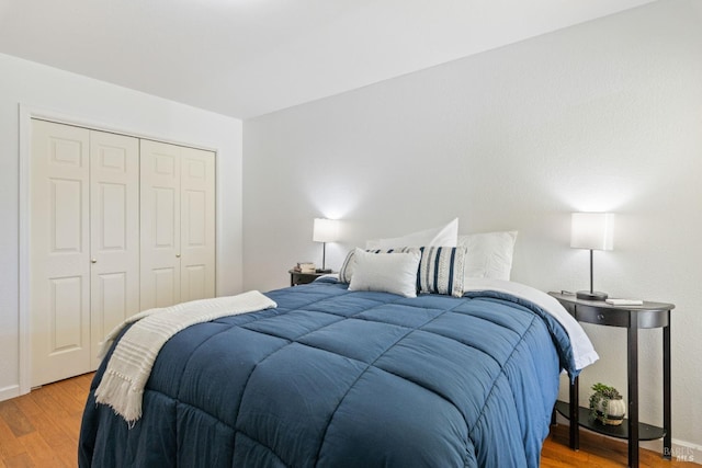 bedroom featuring a closet, light wood-type flooring, and baseboards