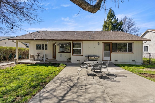 rear view of property with a shingled roof, a lawn, crawl space, a patio area, and fence