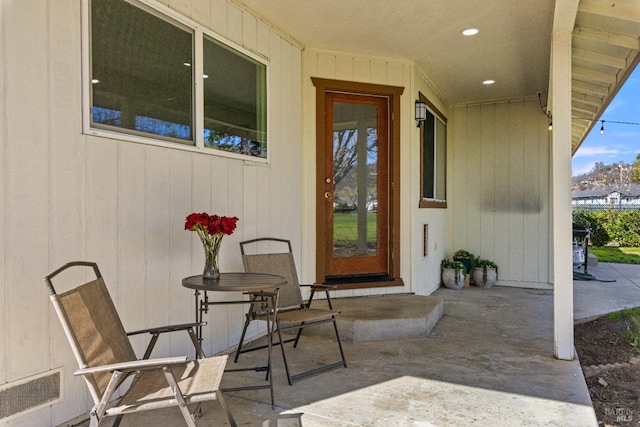 entrance to property featuring visible vents and a patio