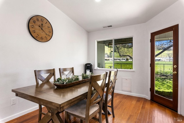 dining room with hardwood / wood-style flooring, baseboards, and visible vents