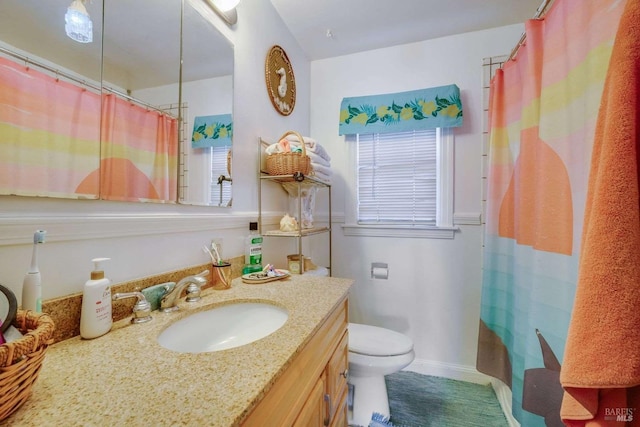 full bath featuring toilet, curtained shower, vanity, and baseboards