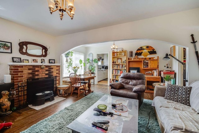 living room featuring a chandelier, arched walkways, and wood finished floors