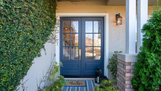 property entrance featuring french doors and stucco siding