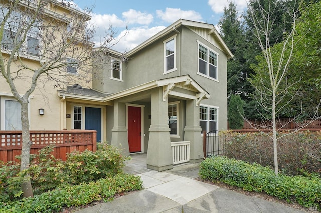 view of front facade featuring fence and stucco siding