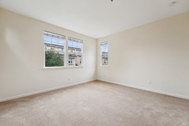 carpeted spare room with baseboards