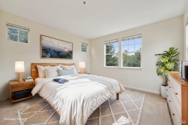 bedroom with baseboards and light colored carpet