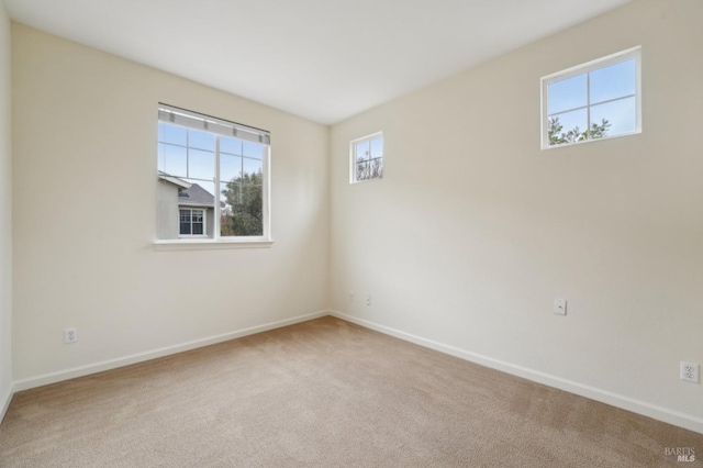 spare room featuring carpet flooring and baseboards