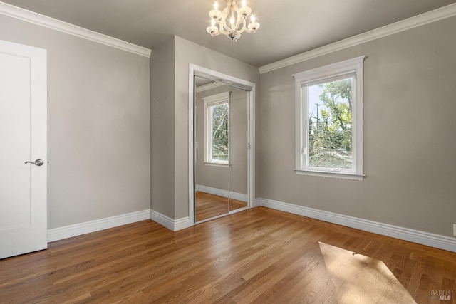 unfurnished bedroom featuring multiple windows, wood finished floors, and baseboards