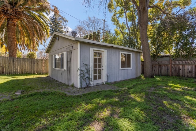 view of outdoor structure with a fenced backyard and an outbuilding