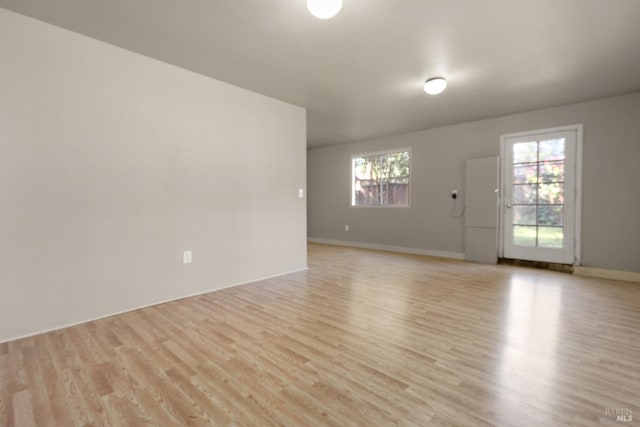 spare room featuring light wood-type flooring and baseboards