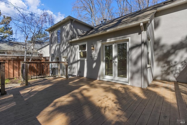 exterior space featuring french doors, fence, a deck, and stucco siding